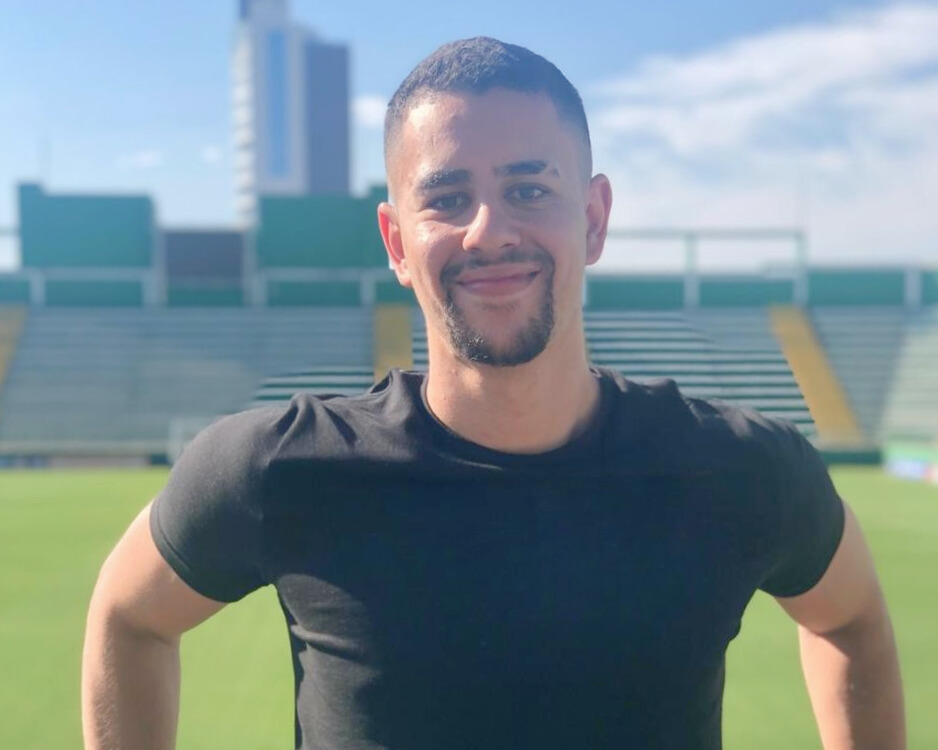 Luiz Felipe, escritor do blog, centralizado com um campo de futebol ao fundo.